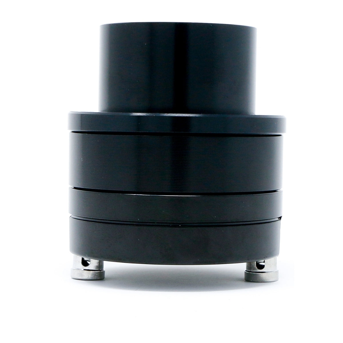 A cylindrical black mechanical component with smooth, shiny surfaces and multiple stacked sections resembles the design of CERWIN-VEGA MOBILE's Pro Series 1" Titanium Component Horn Tweeter -P175T. Supported by two small metal feet, it contrasts vividly against a plain white background.