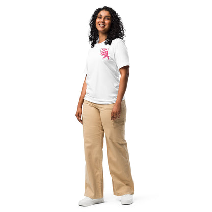 A person with curly hair smiles while facing forward, wearing the Cerwin-Vega Breast Cancer Awareness T-Shirt and beige cargo pants. They stand relaxed, hands by their sides, promoting breast cancer awareness. White sneakers complete the casual look against a plain white background.